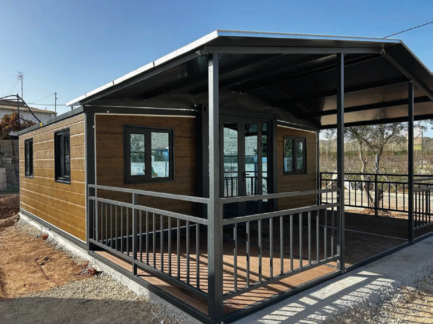 Casa prefabricada expandible con porche instalada en una parcela